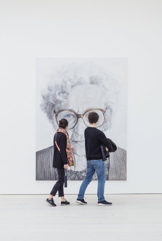 Artwork with two people in front of it.